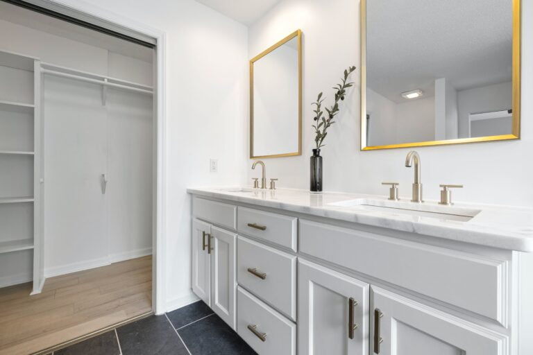 Bathroom remodel with white counters, white countertops, gold accents