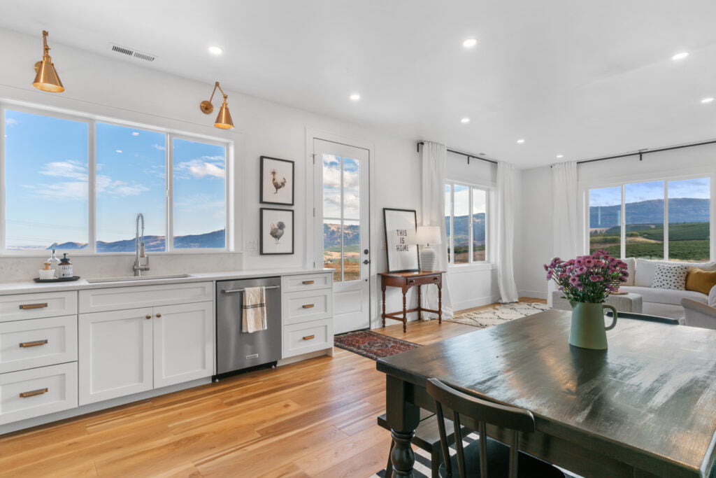 living room and kitchen open floor plan. White counters, dark dining table, and wood flooring.